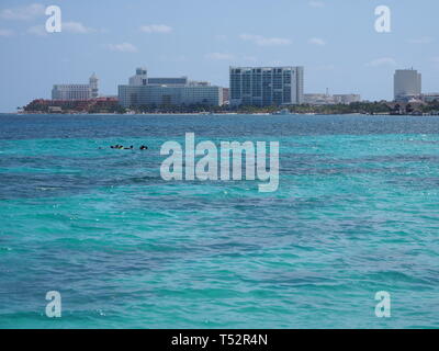 Das türkisfarbene Wasser von Turtle Beach Playa Tortugas am Karibischen Meer Landschaften in Cancun, Quintana Roo Mexiko mit Gebäuden und klaren blauen Himmel Ich Stockfoto