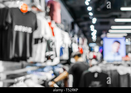 Abstrakte verschwommen von einem Mann Einkaufen in mode kleidung shop im Einkaufszentrum, mit Bokeh hellen Hintergrund. Verschwommenes Bild der männlichen Kleidung zu speichern. Stockfoto