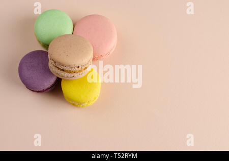 Bunte Makronen oder Macarons in Pastell beige Hintergrund. Gruß oder einladungskarte Konzept. Keine Diät Tag Stockfoto