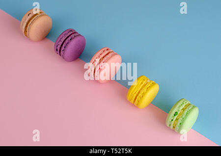 Süße bunte cookies Makronen oder Macarons auf bunten Pastellfarben Hintergrund. Kopieren Sie Platz. Köstliche französische Dessert Konzept. Stockfoto