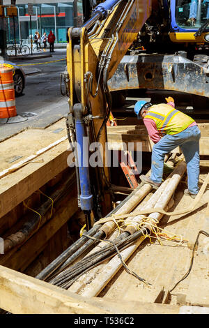 19 APRYL 2019 NY USA Bagger gegraben ein Graben für den Austausch alter Rohre Reparatur der Stadt Kommunikation Pipeline Installation Stockfoto