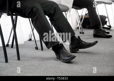 Arbeitslose Menschen warten, die wiederum für ein Interview, das Sitzen auf Bürostühlen in der Diele. Arbeitslosigkeit und Jobsuche. Soziale Probleme Stockfoto