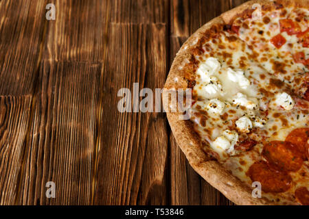 Composite sortierten Pizza auf eine natürliche Holz- Oberfläche der Kiefer Bretter. Tageslicht. Close-up. Freien Speicherplatz zu unterzeichnen. Flache Tiefenschärfe Stockfoto