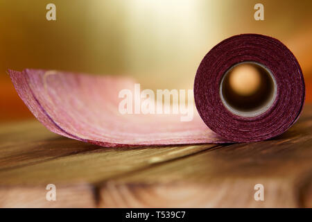 Eine Rolle des Handwerks Material aus Filz und Papier für zu Hause Handarbeit auf einem goldenem Hintergrund. Flache Tiefenschärfe Stockfoto
