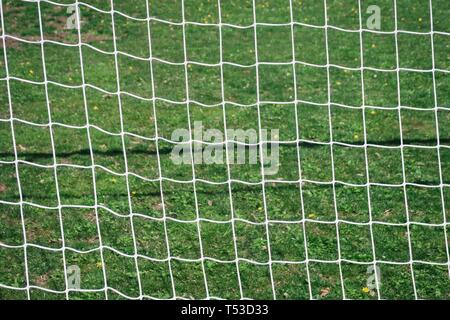 Fußball net gegen grüne Feld Hintergrund Stockfoto