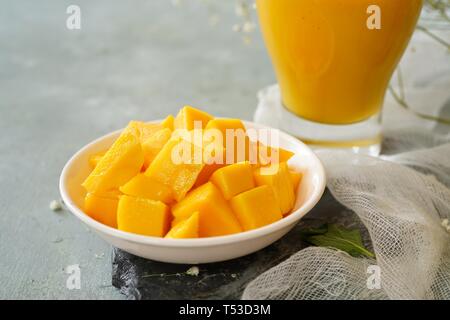 In Scheiben geschnittene reife Mangos mit Lassi seitlich, selektiven Fokus Stockfoto