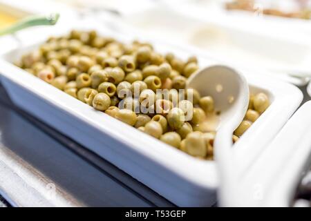 Nahaufnahme von frischen und biologischen Oliven auf einem luxuriösen griechisches Buffet mit einem Löffel servieren. Stockfoto