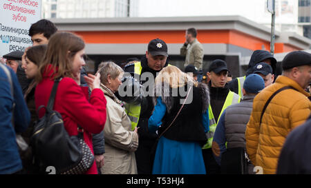 Polizei Zeile bewacht den Eingang zu dem Platz in der Nähe von Kiew Olympiyskiy Stadion am Präsidentendebatte Ereignis. Menge und Polizeikorps in Aktion. Stockfoto