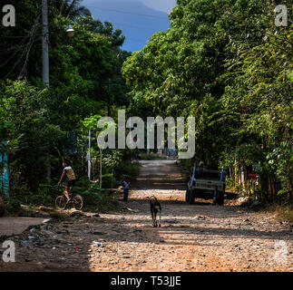 Latin boy Reiten Fahrrad auf unbefestigte Straße in Guatemaltekischen Dorf Stockfoto