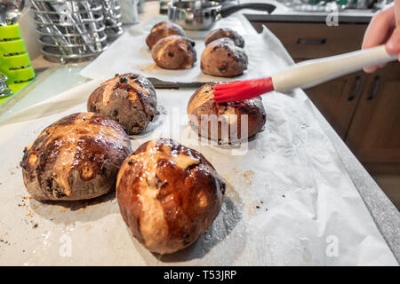 Hausgemachte Hot Cross Buns auf ein Backblech. Stockfoto