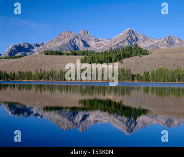 USA, Idaho, Sawtooth National Recreation Area, Gipfel der Sägezahn Bereich spiegeln sich in kleinen Rotbarsch See am frühen Morgen. Stockfoto