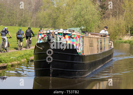 Landschaft Nahaufnahme der Gegenschiff auf UK Kanal im Frühjahr Sonnenschein, Single Mann Lenkung hinten. Radfahrer fahren auf dem Kanal-Schlepppfad. Stockfoto