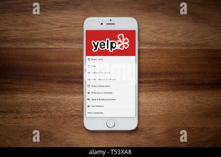 Ein iPhone mit Yelp Website beruht auf einem einfachen Holztisch (nur redaktionelle Nutzung). Stockfoto