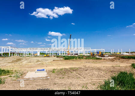 Montage einer riesigen Beton Skelett der industriellen Gebäude mit Maschinen, Menschen arbeiten. Blick auf die Baustelle. Stockfoto