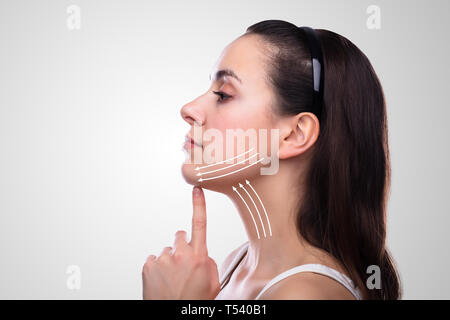 Frau mit Pfeilen auf Ihr Gesicht auf weißem Hintergrund Stockfoto