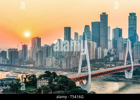 CHONGQING, CHINA - November 03: Ansicht von Chongqing Stadt Gebäude und die Dongshuimen Brücke entlang des Yangtze River bei Sonnenuntergang am November 03, 2018 Stockfoto