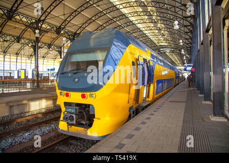 Hauptbahnhof Amsterdam Centraal. Vor gelb gelb-blauen Wagen der Traditiona Züge in Hollan Stockfoto