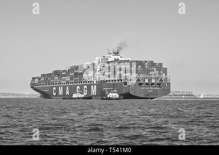 Schwarz-weiß-Foto des Containerschiffs CMA CGM CENTAURUS, das vor dem Anlegen in Long Beach, Kalifornien, von zwei Schleppern um 180 Grad gedreht wurde. USA. Stockfoto
