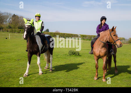 Kent. UK. Zwei Reiter gehen für ein Hack in der Landschaft auf einem schönen sonnigen Tag. Stockfoto