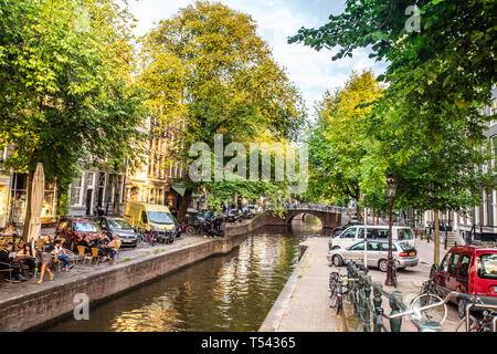 AMSTERDAM, NIEDERLANDE - 31 AUGUST, 2018: Blick entlang Kanal von Amsterdam gesehen mit Brücke und Fahrräder im Blick. Stockfoto