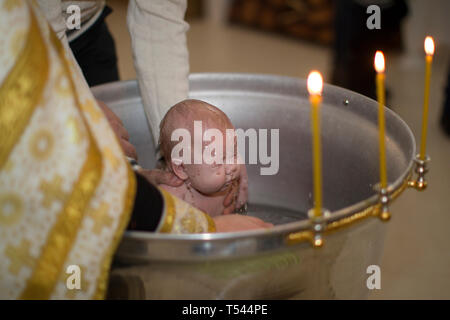 Belarus, die Stadt Gomel am 25. Oktober 2017. Kirche von der Farm. Taufe des Babys. Waschen Sie das Baby bei der Annahme der Religion. Stockfoto