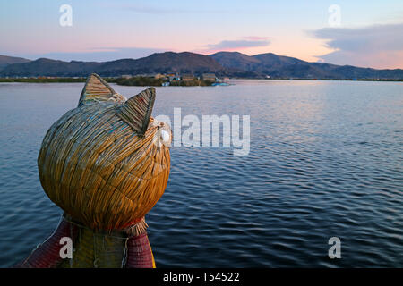 Traditionelle Totora Reed Boot mit Puma Kopf Bug gegen Titicaca See bei Sonnenuntergang, Puno, Peru Stockfoto