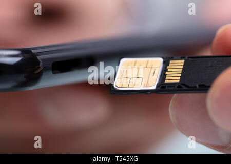 Nahaufnahme der Person Einlegen der SIM-Karte und Speicherkarte im Handy Stockfoto