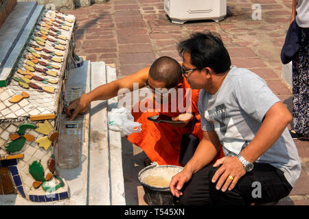 Th1064 Thailand, Bangkok, Wat Pho, Phra Maha Chedi, Mönch Beratung workman Anwendung Gedenktafel Chedi Stockfoto