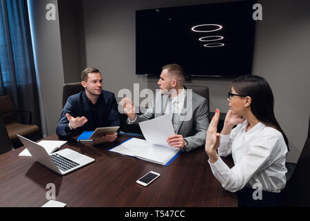 Geschäftsleute, die sich mit digitalen Tablet-PC, Laptop und Papiere in Treffen in Luxus Tagungsraum Stockfoto