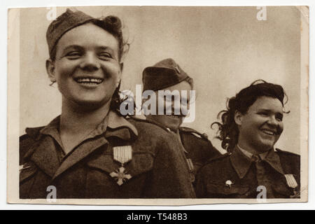 Im Mai 1945 nehmen die Frauen des 1. Tschechoslowakischen Armeekorps (První československý armádní sbor) in der UdSSR an der Militärparade auf dem Altstädter Ring (Staroměstské náměstí) in Prag Teil. Im Vordergrund ist der tschechoslowakische Armeemannsarzt Malvína Fantová dargestellt. Sie war das erste weibliche Mitglied der aufstrebenden 1. Tschechoslowakischen Truppen an der Ostfront. Die Frauen wurden nach der Schlacht von Sokolovo 1943 mit dem Tschechoslowakischen Kriegskreuz (Československý válečný Kříž) geschmückt. Mit freundlicher Genehmigung der Azoor Postcard Collection. Stockfoto