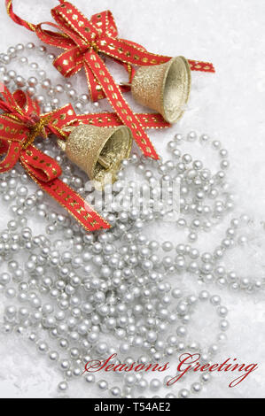 Season's Greetings Text mit schönen Weihnachten Glocken mit roten Bändern und Perlen Stockfoto