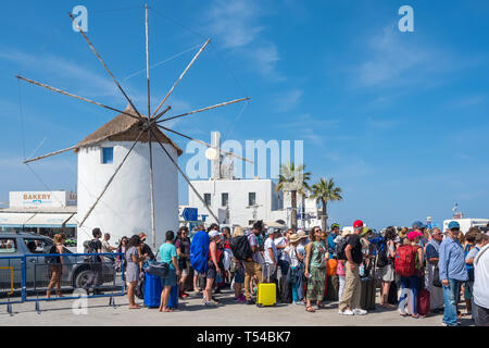 Paros, Griechenland - Juni 5, 2018: Unbekannter Touristen wartenden Boot mit einem traditionellen zykladischen Windmühle im Hintergrund auf der Insel Paros, Fähre, Stockfoto