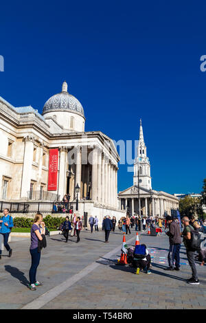 Von außen die National Gallery am Trafalgar Square und St Martin-in-the-Fields Kirche im Hintergrund, Menschen Zeichnen mit Kreide, London, UK Stockfoto