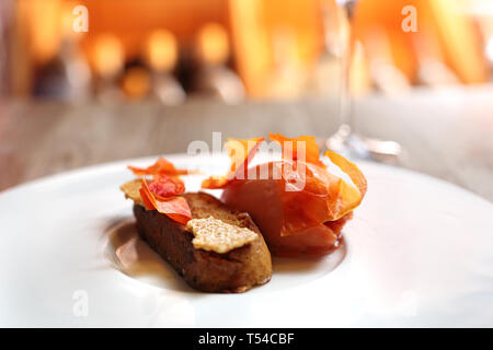 Eine exquisite und elegante Dessert serviert mit einem Glas Weißwein Stockfoto