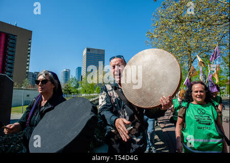 Rotterdam, Südholland, Niederlande. 20 Apr, 2019. Ein Aktivist gesehen spielt eine Bodhran und riefen Slogans während des Protestes. einem Trauerzug wurde von der internationalen Bewegung durchgeführt, Aussterben Rebellion in Rotterdam. Mit dieser Aktion, die Bewegung fordert die niederländische Regierung ein Klima Not wirken auf einen Delta Plan Klima für Rotterdam, Null CO2-Emissionen im Jahr 2025 zu erklären, einschliesslich der Hafen von Rotterdam. Credit: Ana Fernandez/SOPA Images/ZUMA Draht/Alamy leben Nachrichten Stockfoto