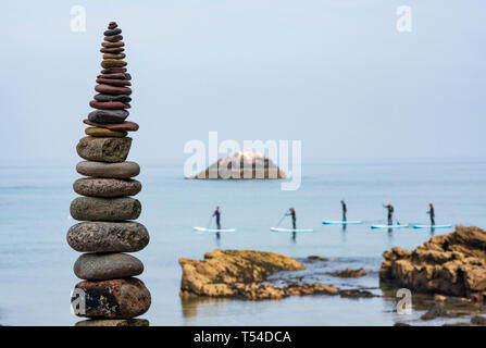 Dunbar, Schottland, Großbritannien. 20 Apr, 2019. Paddel Boarder und Stein am Auge Cave Beach Stack in Dunbar bei der Eröffnung der Europäischen Stein Stacking Meisterschaft 2019. Credit: Iain Masterton/Alamy leben Nachrichten Stockfoto