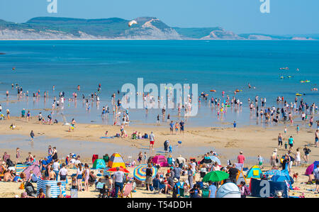 Lyme Regis, Dorset, Großbritannien. 20. April 2019. UK Wetter: Urlauber und Badegäste pack den hübschen Strand im Badeort von Lyme Regis in Sizzling Hot Ostern Samstag Sonne am heißesten Tag des Jahres so weit zu sonnen. Am frühen Nachmittag auch der Kiesstrand war, rammte mit Besuchern. Credit: Celia McMahon/Alamy Leben Nachrichten. Stockfoto