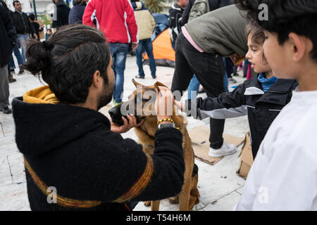 Athen, Attika, Griechenland. 21 Mai, 2019. Flüchtlinge gesehen spielen mit einem Hund am Syntagma Platz nach der Zwangsräumung. Flüchtlinge auf Bussen begeben Sie sich in die Lager nach 2 Tag Camping am Syntagma-Platz übertragen werden, die nach ihrer Vertreibung aus einem Gebäude verlassen in Exarchia, in Athen. Credit: Nikos Pekiaridis/SOPA Images/ZUMA Draht/Alamy leben Nachrichten Stockfoto