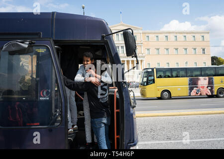 Athen, Attika, Griechenland. 21 Mai, 2019. Zwei Männer sind Flüchtlinge gesehen einander umarmen auf die Polizei bus Tür nach dem Rauswurf. Flüchtlinge auf Bussen begeben Sie sich in die Lager nach 2 Tag Camping am Syntagma-Platz übertragen werden, die nach ihrer Vertreibung aus einem Gebäude verlassen in Exarchia, in Athen. Credit: Nikos Pekiaridis/SOPA Images/ZUMA Draht/Alamy leben Nachrichten Stockfoto