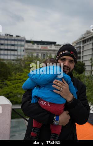 Athen, Attika, Griechenland. 21 Mai, 2019. Ein flüchtling Vater gesehen hat, sein Kind tragen am Syntagma Platz nach der Zwangsräumung. Flüchtlinge auf Bussen begeben Sie sich in die Lager nach 2 Tag Camping am Syntagma-Platz übertragen werden, die nach ihrer Vertreibung aus einem Gebäude verlassen in Exarchia, in Athen. Credit: Nikos Pekiaridis/SOPA Images/ZUMA Draht/Alamy leben Nachrichten Stockfoto