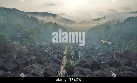 Peking, China. 20 Apr, 2019. Luftbild genommen am 20. April 2019 zeigt der Nebel - ummantelte Dong Dorf Zhaoxing in Liping County, im Südwesten Chinas Provinz Guizhou. Credit: Ou Dongqu/Xinhua/Alamy leben Nachrichten Stockfoto