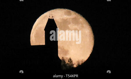 Daugendorf, Deutschland. 20 Apr, 2019. Hinter der Wallfahrtskirche St. Johannes Baptist auf dem Berg" Bussen' der Mond in der Osternacht steigt. Foto: Thomas Warnack/dpa/Alamy leben Nachrichten Stockfoto