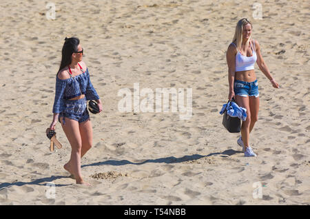 Bournemouth, Dorset, Großbritannien. 21. Apr 2019. UK Wetter: Die hitzewelle weiter mit warmem und sonnigem Wetter, wie Beachgoers Kopf zum Meer die Wärme und Sonnenschein in Bournemouth Strände für Ostern - Mitte Morgen und schon Strände zu genießen sind verpackt, als Sonnenanbeter gehen Sie früh in ihrem Lebensraum zu erhalten. Zwei junge Frauen in kurzen Hosen Laufen auf Sand. Credit: Carolyn Jenkins/Alamy leben Nachrichten Stockfoto