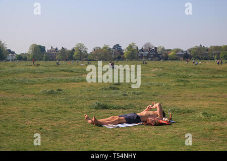 London, Großbritannien. 21 Apr, 2019. Ein Mann beim Sonnenbaden auf einer sonnigen und warmen Ostersonntag auf Wimbledon Common Credit: Amer ghazzal/Alamy leben Nachrichten Stockfoto