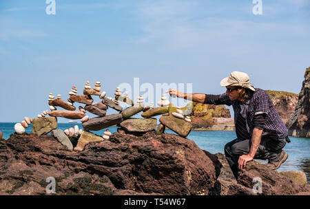 Dunbar, East Lothian, Schottland, Großbritannien. 21. Apr 2019. Europäische Stein stacking Meisterschaft: Pedro Duran, aus Spanien und Gesamtsieger des letzten Jahres Wettbewerb Salden Steine in den künstlerischen Wettbewerb, so dass Wettbewerber 3 Stunden nichts von Steinen oder gefundene Gegenstände Wettbewerb auf Augenhöhe Cave Beach zu erstellen Stockfoto