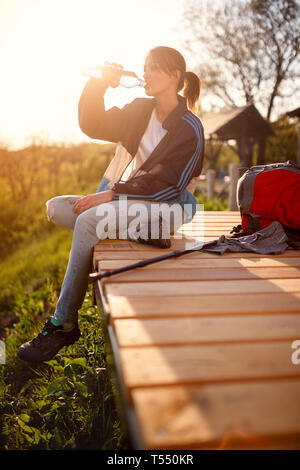 Junge Wanderer Trinkwasser aus der Flasche auf Pause vom Wandern in der Natur Stockfoto