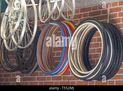 Sortiment von bunten Fahrrad Reifen und Stahlfelgen hängend an einem Geschäft Wand Stockfoto