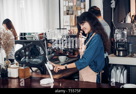 Asiatischer Barista verwenden Tablet um von Kunden im Coffee Shop, cafe Besitzer schreiben Drink an der Bar, Essen und Trinken, Geschäftskonzept, Service Stockfoto