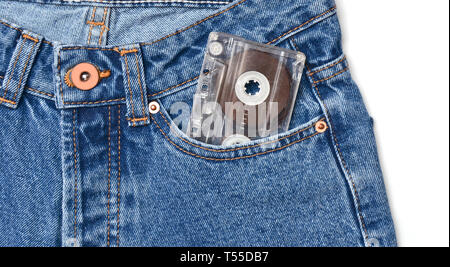 Audio Kassette in einer Tasche der altmodischen blauen Jeans auf einem weißen Hintergrund. Stockfoto