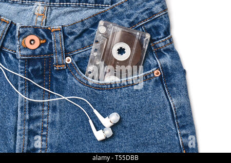 Audio Kassette in einer Tasche der altmodischen blauen Jeans und Kopfhörer auf einem weißen Hintergrund. Stockfoto